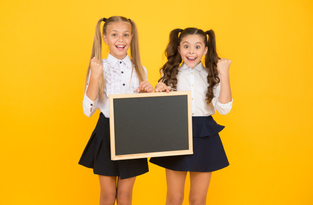 视觉传达。很高兴通知。女生告诉你。女学生拿着空白的黑板抄写空间。女生校服拿黑板。回到学校的概念。学校即将举行的活动图片下载