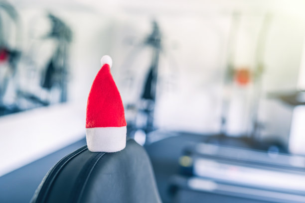 小圣诞帽在体育馆对面的设备和成排的慢跑模拟器。圣诞节及新年优惠的象征及概念。副本的空间。图片下载