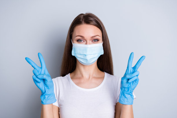 漂亮女士的照片显示v符号双手手套保持社会距离去过医院检查健康人遇见朋友戴保护脸医用口罩孤立的灰色背景图片下载