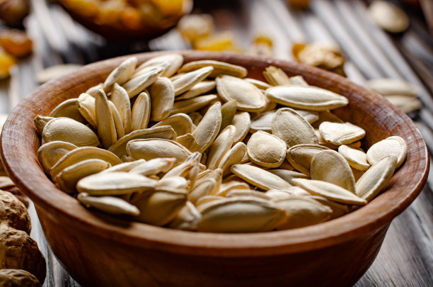 厨房餐桌上的食物背景是木碗里的南瓜子图片下载