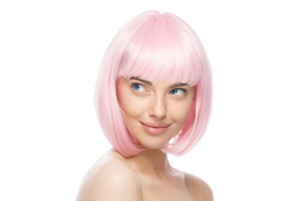 年轻美丽的微笑女孩戴着粉红色的假发，站在赤裸的肩膀和脖子，准备派对，看一边，孤立在白色的背景图片下载