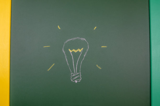 在一个特写画面中，用粉笔在一块绿色板上手绘的灯泡。观念、思想、光的概念图片下载