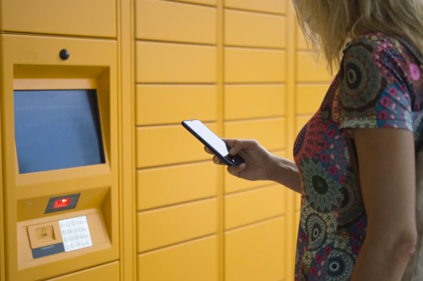 从自动储物柜取包裹的女人图片下载