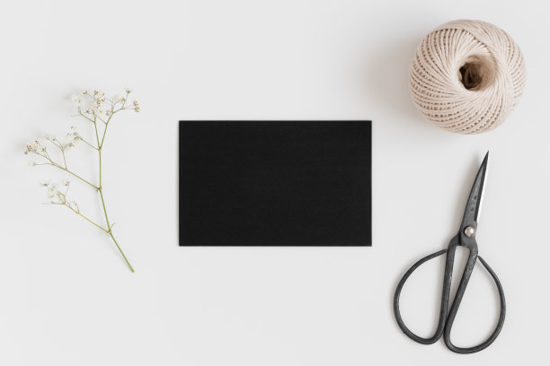 顶视图的黑卡模型与gypsophila和工作配件在白色的桌子上。图片下载