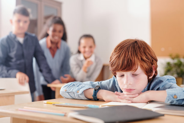 一个不高兴的学生，他把下巴放在桌子上，一边看抄写本上的笔记图片下载