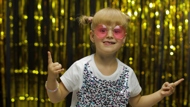 孩子们跳舞，庆祝胜利，胡闹。女孩摆着箔窗帘的背景图片下载