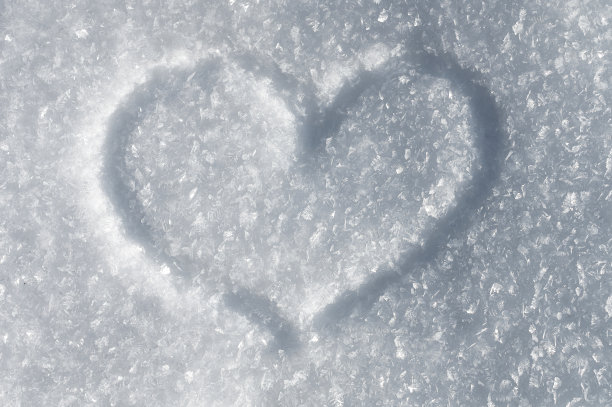 冬日背景下闪闪发光的雪晶体在阳光下。爱心的象征图片下载