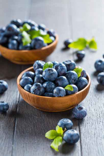 新鲜的有机蓝莓碗在木背景。图片下载
