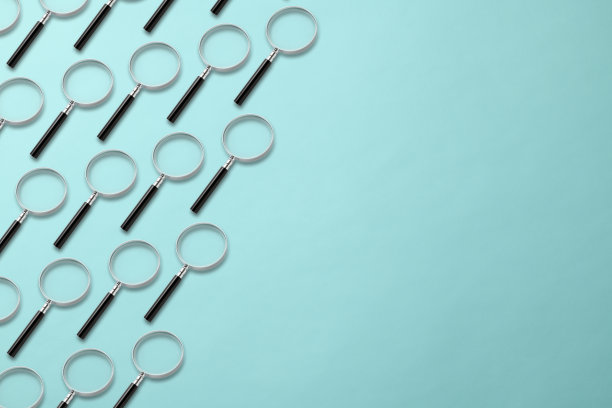 许多放大镜在浅蓝色的背景上排成一行。图片下载