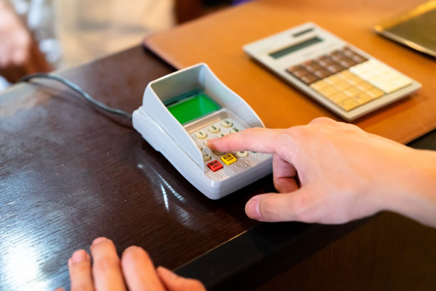 一个男人的手的特写，当他输入他的密码支付他的信用卡图片下载