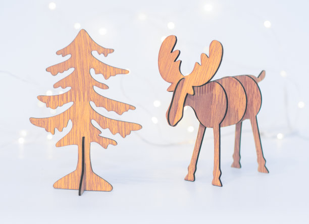 圣诞装饰驯鹿和圣诞树是手工制作在白色背景上的背景bokeh的节日彩灯。图片下载