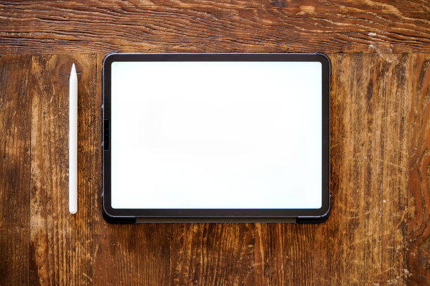 平板电脑和铅笔平放在木桌上图片下载