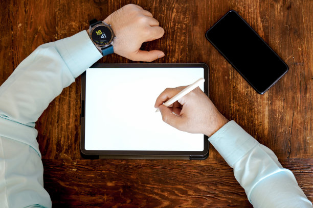 商务人士在专业平板电脑上书写、绘图、做笔记，平板铅笔放在智能手机旁边图片下载