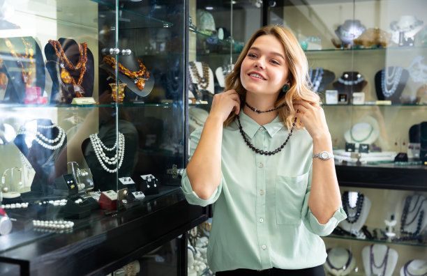 女孩正在试一条石榴石项链图片下载