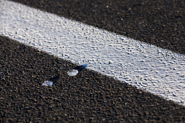 一个白色道路标记的柏油路的特写图片下载