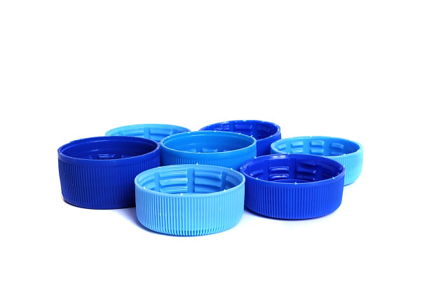白色背景上孤立的蓝色塑料瓶盖。回收塑料垃圾的解决方案图片下载