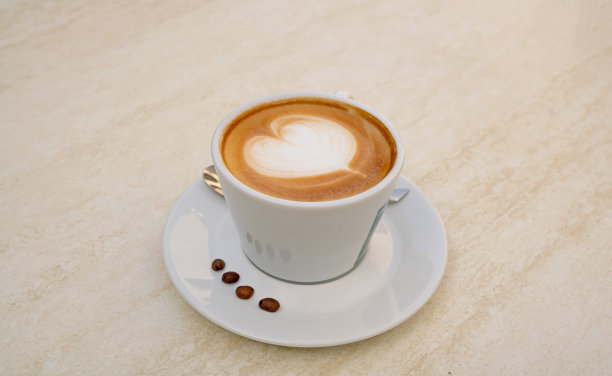 一杯卡布奇诺咖啡与咖啡豆背景图片图片下载