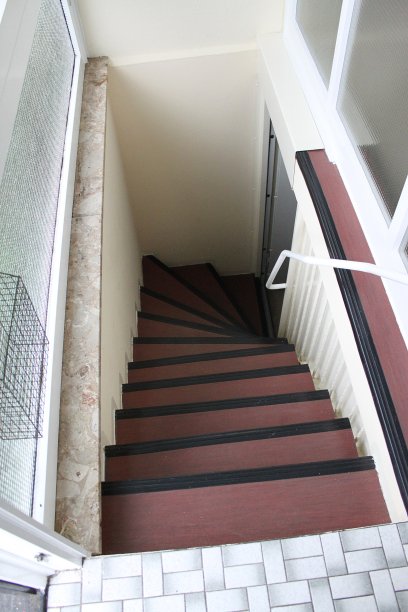 垂直拍摄的深红色和黑色的楼梯内的一个家图片下载