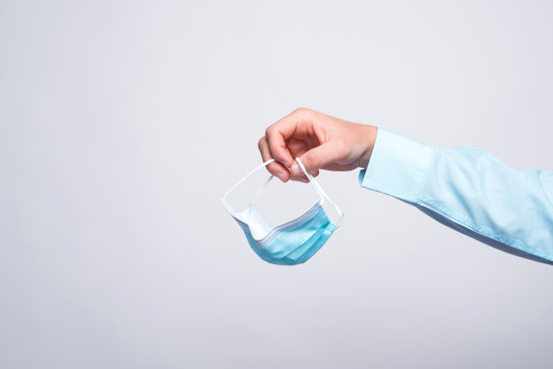 男人的手拿着医用面膜的特写照片图片下载