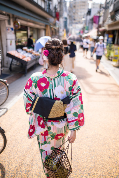 年轻女子在汤方走在传统的日本购物街的后视图图片下载