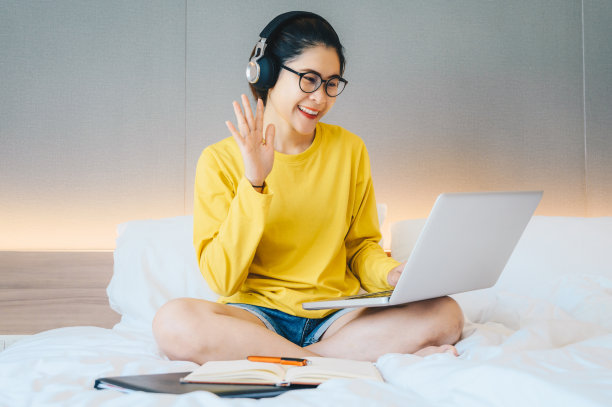 在家里工作和通过笔记本电脑视频会议发言的女性肖像。图片下载