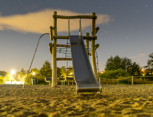 操场上木制结构上的金属滑梯图片下载