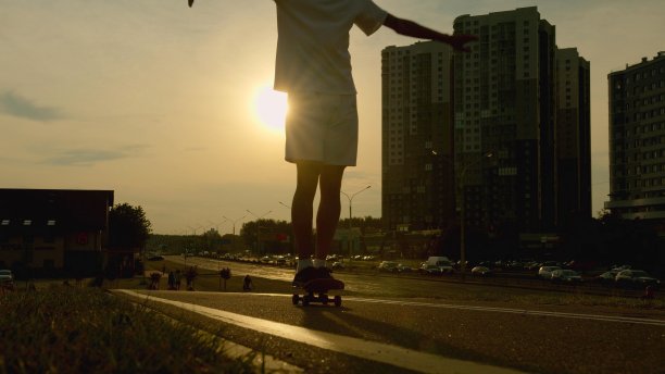 一个年轻人在一个小镇上玩滑板的晚上的照片图片下载