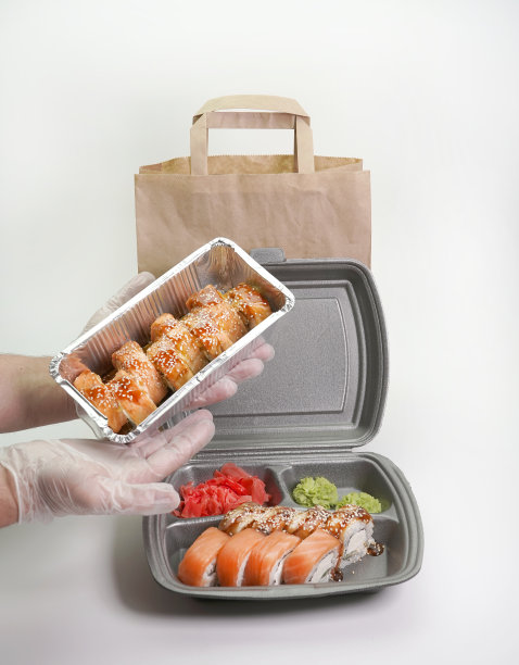 日本寿司卷装在锡箔盒里，背景是孤立的白色。交付的概念图片下载