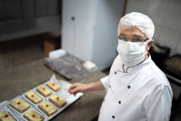 一个厨师用面具准备蛋糕的肖像图片下载