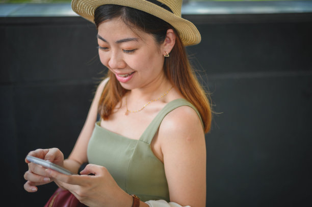 一名亚洲年轻女性游客使用智能手机的特写照片图片下载