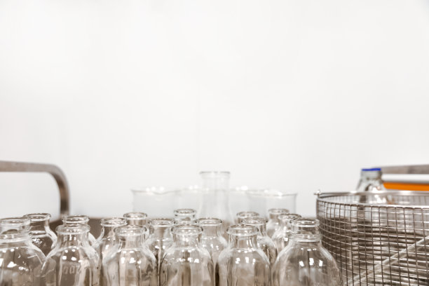 推车上放着空的、透明的玻璃药瓶。医药制造业背景图片下载