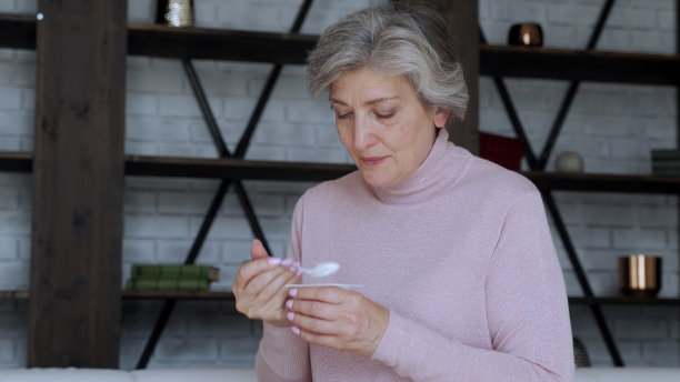 一个坐在家里沙发上吃酸奶的老妇人的肖像图片下载