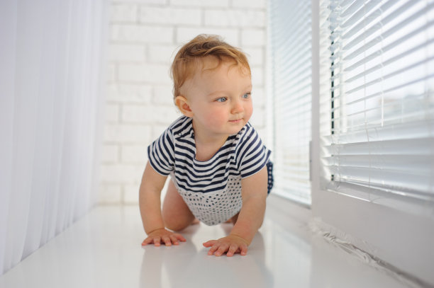 可爱的小婴儿在地板上爬。图片下载