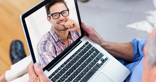 一个用笔记本电脑进行视频通话的老人。图片下载