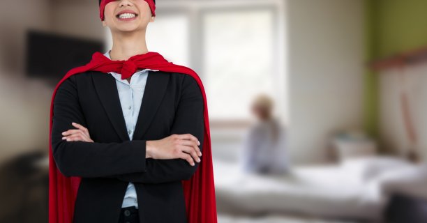 一名男子身穿斗篷，双臂交叉，微笑着站在医院病房的上方图片下载