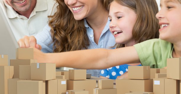 一对白种人夫妇和他们的孩子使用笔记本电脑在网上购物与一堆盒子图片下载