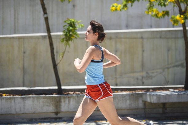 精力充沛的年轻女性在公园里跑过照相机图片下载