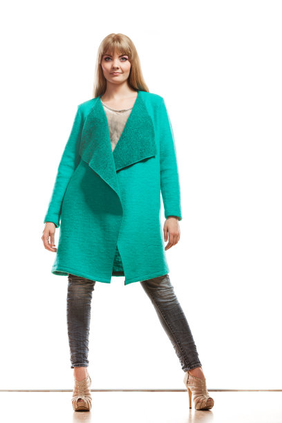穿着绿色外套的长裙时尚女士。图片下载