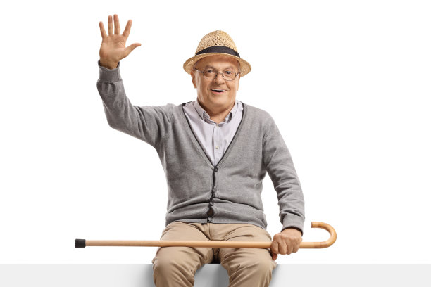 一位老人坐在一块空白的广告牌上挥手图片下载