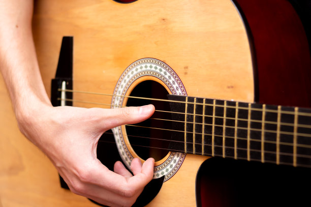 那家伙弹吉他。关闭计划。木吉他。图片下载