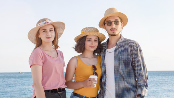 三个朋友在海滩上享受暑假。图片下载