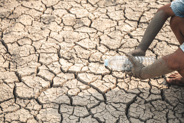 小男孩等待饮用水来度过这个干旱，概念干旱和危机的环境。图片下载