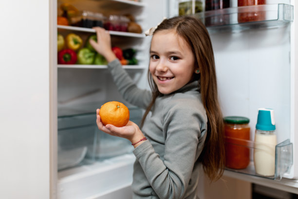 从冰箱里拿生食物的女孩图片下载