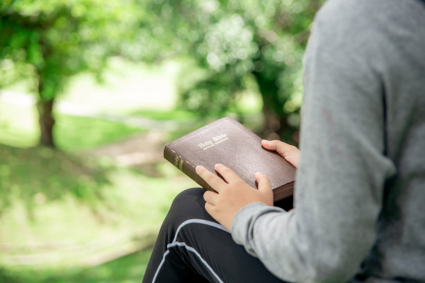一个亚洲基督教女孩用皮革封面的圣经。图片下载