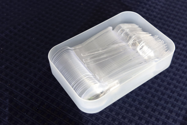 将塑料汤匙和叉子放在桌上的容器内图片下载