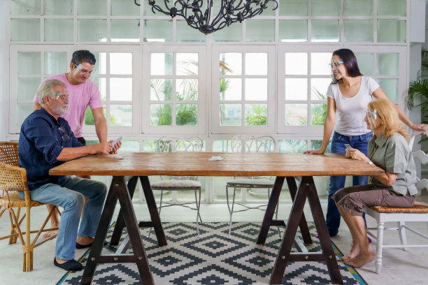 夸卡亚裔家庭人人戴着面罩在家一起玩扑克牌图片下载