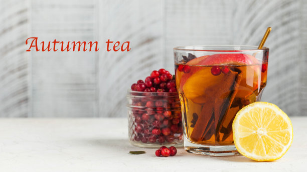 秋季美食照片与热茶肉桂，柠檬，苹果，浆果和香料在一个透明的杯子。文本秋天。图片下载