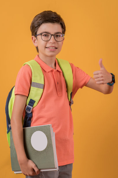 快乐的学生与背包在彩色的背景。图片下载