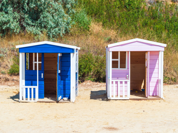 两个木制的房子供孩子们在操场上玩耍——给男孩和女孩们图片下载