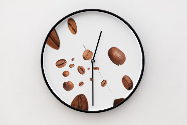 咖啡豆落在白色的时钟上。喝咖啡的时间图片下载
